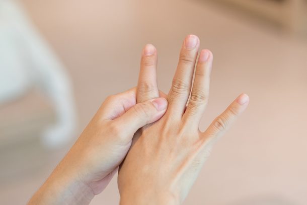 donna-toccandosi-cisti-tendinea-dita-della-mano Donna che si tocca le dita della mano e soffre di cisti tendinea