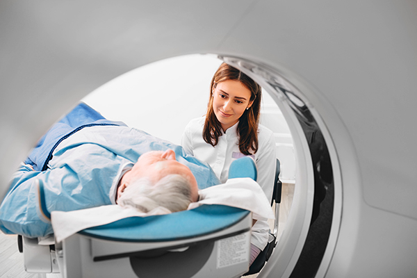 Dottoressa in ospedale che prepara il paziente alla tomografia computerizzata per l’approfondimento dei sintomi dell’encefalite