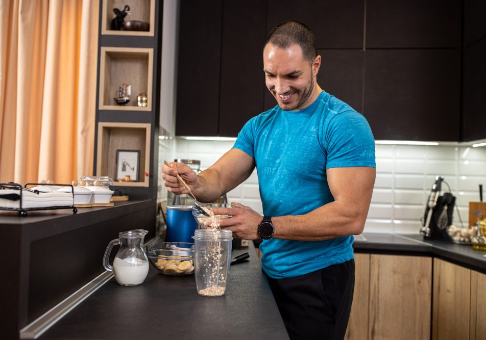 giovane-sportivo-che-prepara-alimenti-ricchi-di-fibre Giovane sportivo si prepara un pasto con alimenti ricchi di fibre