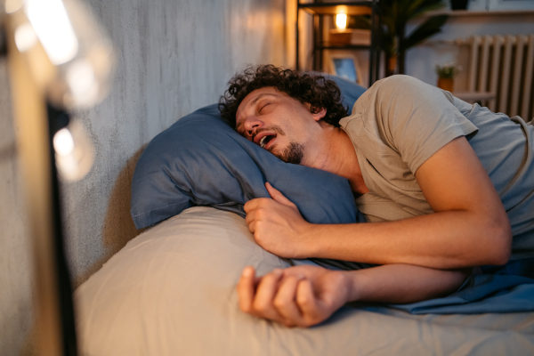 Giovane uomo che dorme e soffre di apnea notturna