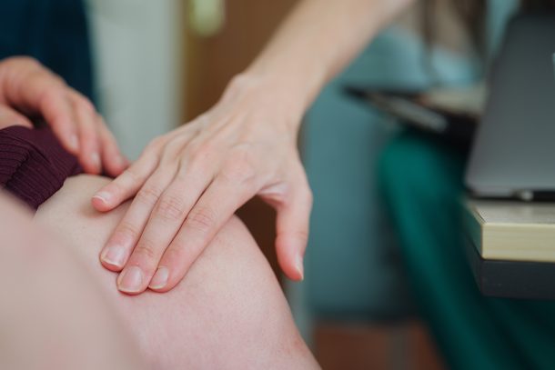 medico-a-domicilio-visitando-paziente-donna-con-trombosi-venosa-profonda Medico a domicilio che visita una paziente donna con la trombosi venosa profonda, toccandole delicatamente l’area delle gambe