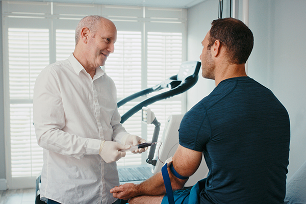 In una clinica medico-sportiva, dottore che esamina un paziente sportivo non agonista per il rilascio del certificato medico non agonistico