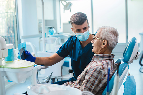 Paziente che soffre di pulpite dal dentista mentre osserva e ottiene l'esito della sua panoramica dentale
