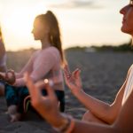 Gruppo di persone in spiaggia svolgono tecniche di rilassamento come calmanti naturali