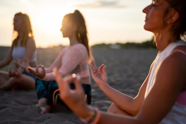 persone-eseguono-tecniche-di-rilassamento-come-calmanti-naturali Gruppo di persone in spiaggia svolgono tecniche di rilassamento come calmanti naturali