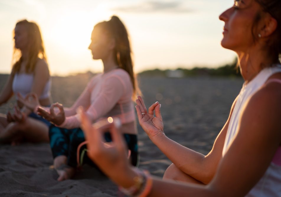 Gruppo di persone in spiaggia svolgono tecniche di rilassamento come calmanti naturali