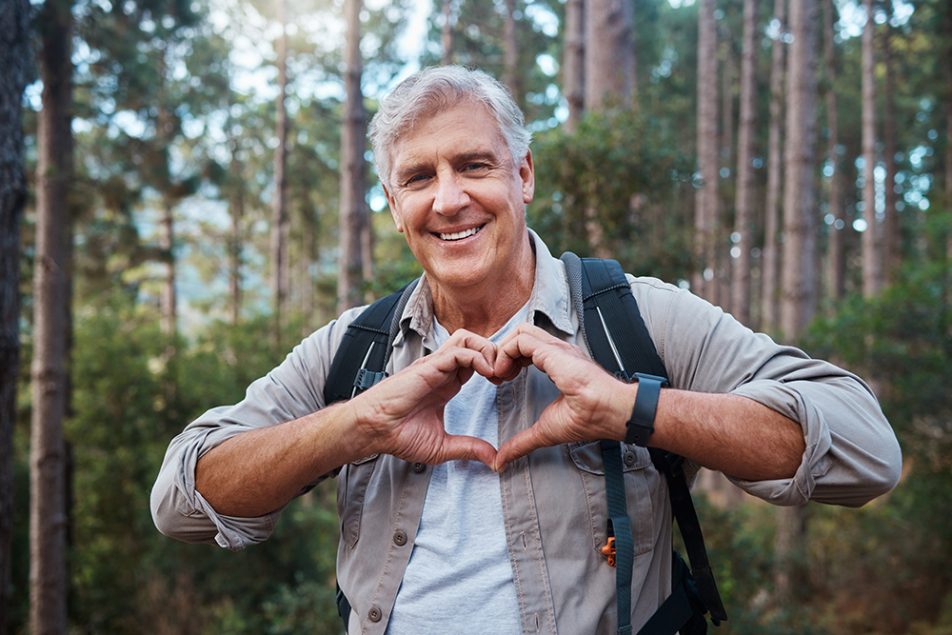 signore-formando-cuore-con-mani-prevenendo-sintomi-infarto-uomo-attraverso-attivita-fisica Uomo maturo che forma un cuore con le mani e previene i sintomi dell’infarto attraverso l’attività fisica ed escursioni nella natura