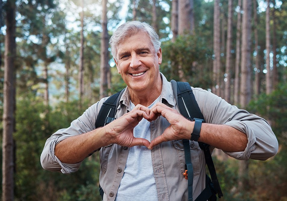 signore-formando-cuore-con-mani-prevenendo-sintomi-infarto-uomo-attraverso-attivita-fisica Uomo maturo che forma un cuore con le mani e previene i sintomi dell’infarto attraverso l’attività fisica ed escursioni nella natura