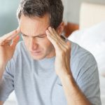 Uomo con forte mal di testa, tra i sintomi della meningite