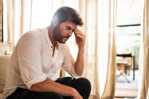 uomo-con-sintomi-meningoencefalite Uomo si tocca le tempie a causa di mal di testa intenso, tra i sintomi della meningoencefalite