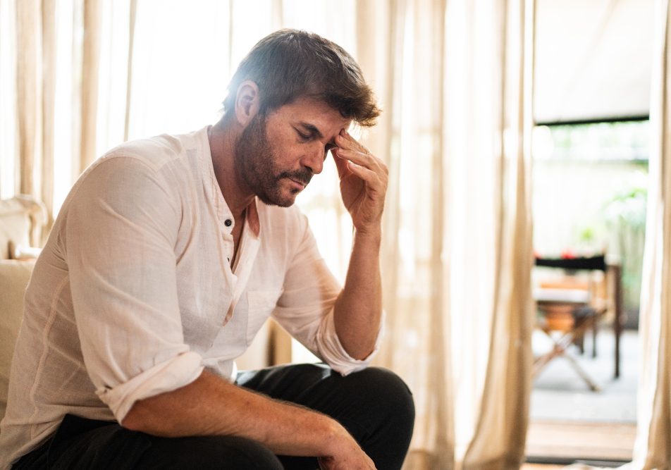 uomo-con-sintomi-meningoencefalite Uomo si tocca le tempie a causa di mal di testa intenso, tra i sintomi della meningoencefalite