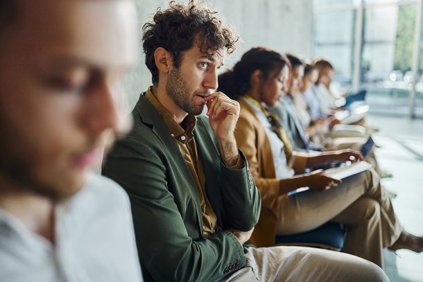 Uomo seduto in sala d’attesa per un colloquio di lavoro che avverte ansia sociale
