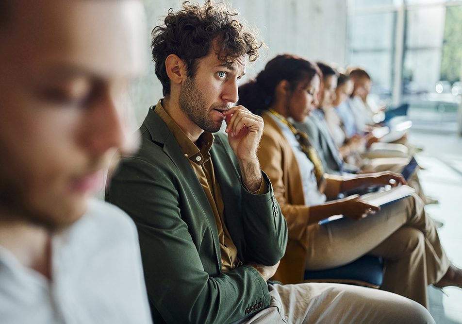 uomo-in-attesa-di-colloquio-avvertendo-ansia-sociale Uomo seduto in sala d’attesa per un colloquio di lavoro che avverte ansia sociale