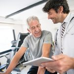 Uomo maturo in un centro di medicina dello sport in compagnia del medico che si sottopone a una visita medico sportiva non agonistica, per poter praticare attività fisica in salute e sicurezza