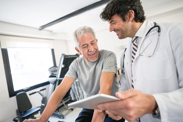 Uomo maturo in un centro di medicina dello sport in compagnia del medico che si sottopone a una visita medico sportiva non agonistica, per poter praticare attività fisica in salute e sicurezza