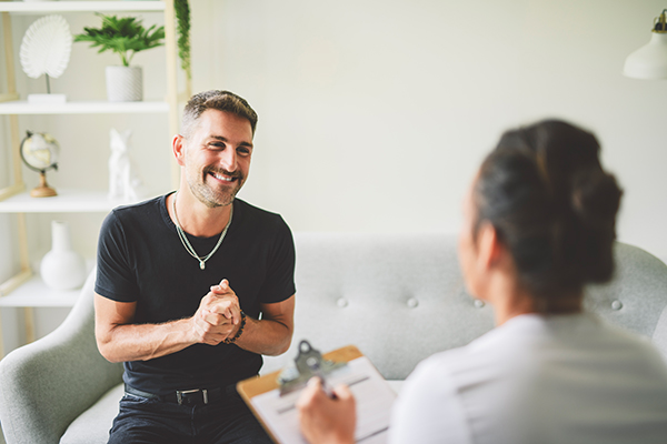 Uomo sorridente che recupera il sorriso grazie alla riabilitazione dall’encefalite attraverso il supporto logopedico e psicologico