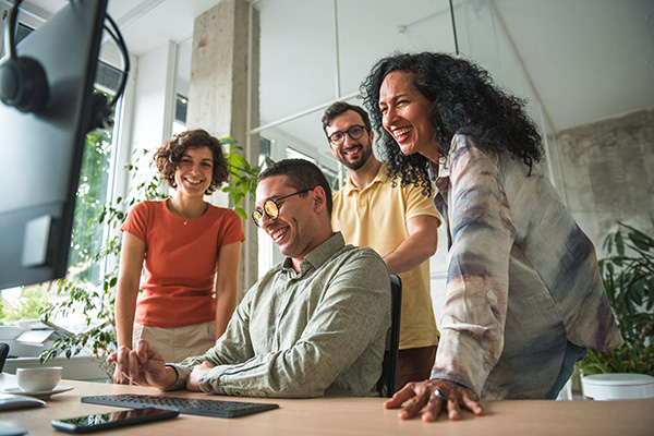 Gruppo di colleghi davanti al PC per una videochiamata, che uniscono le loro forze per favorire il benessere organizzativo del singolo e aziendale