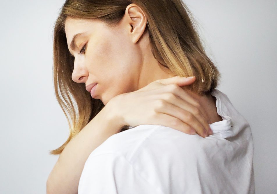 Donna con la mano sulla spalla che soffre di malattie reumatiche