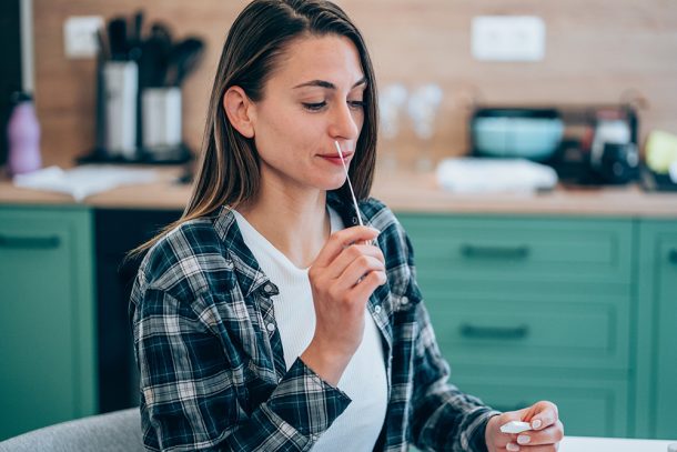 Donna che osserva una perdita dell’olfatto e del gusto esegue un autotest per il Coronavirus a casa