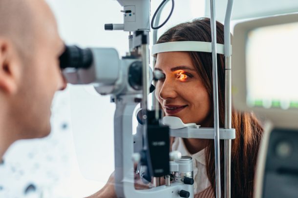Giovane donna dall'oculista mentre esegue un intervento di laser agli occhi