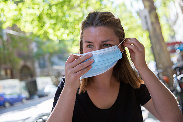 Donna a rischio di contrarre il Covid senza febbre che esce indossando una mascherina per prevenire il contagio
