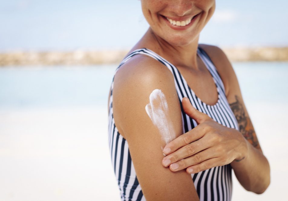 donna-spalmando-crema-solare-per-prevenire-melanoma-benigno Donna al mare si spalma la crema per proteggere la pelle e prevenire melanoma benigno