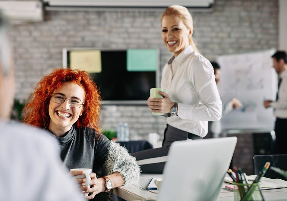impiegata-svagandosi-durante-pausa-caffe-per-calibrare-work-life-balance Giovane impiegata che si svaga in compagnia del collega durante una pausa caffè per calibrare il suo work-life balance
