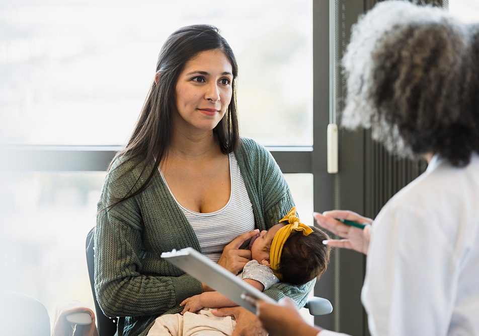 madre-e-bebe-dalla-dottoressa-superando-baby-blues Madre presso la clinica medica insieme al suo bebè, consultando la dottoressa al fine di superare il baby blues