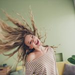 Ragazza gioiosa che si gode un momento di divertimento in casa, attraverso una cura a base di musica