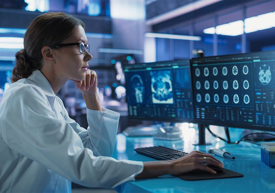 Ricercatrice che esamina al computer una scansione cerebrale per approfondire lo studio degli integratori per la memoria nei pazienti affetti da malattie neurodegenerative