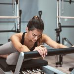 giovane donna esegue esercizio di pilates reformer