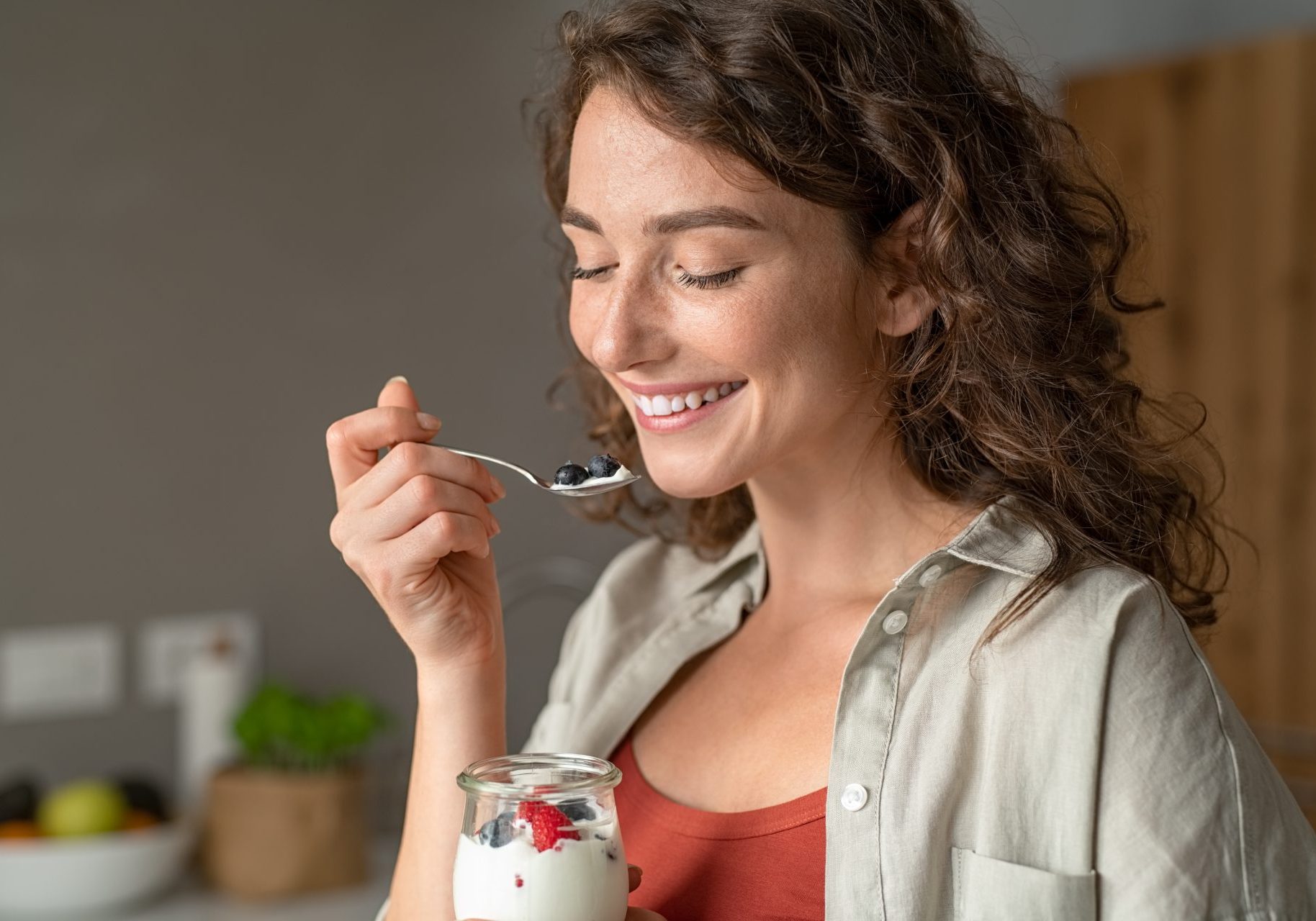 giovane donna sorridente mangia yogurt