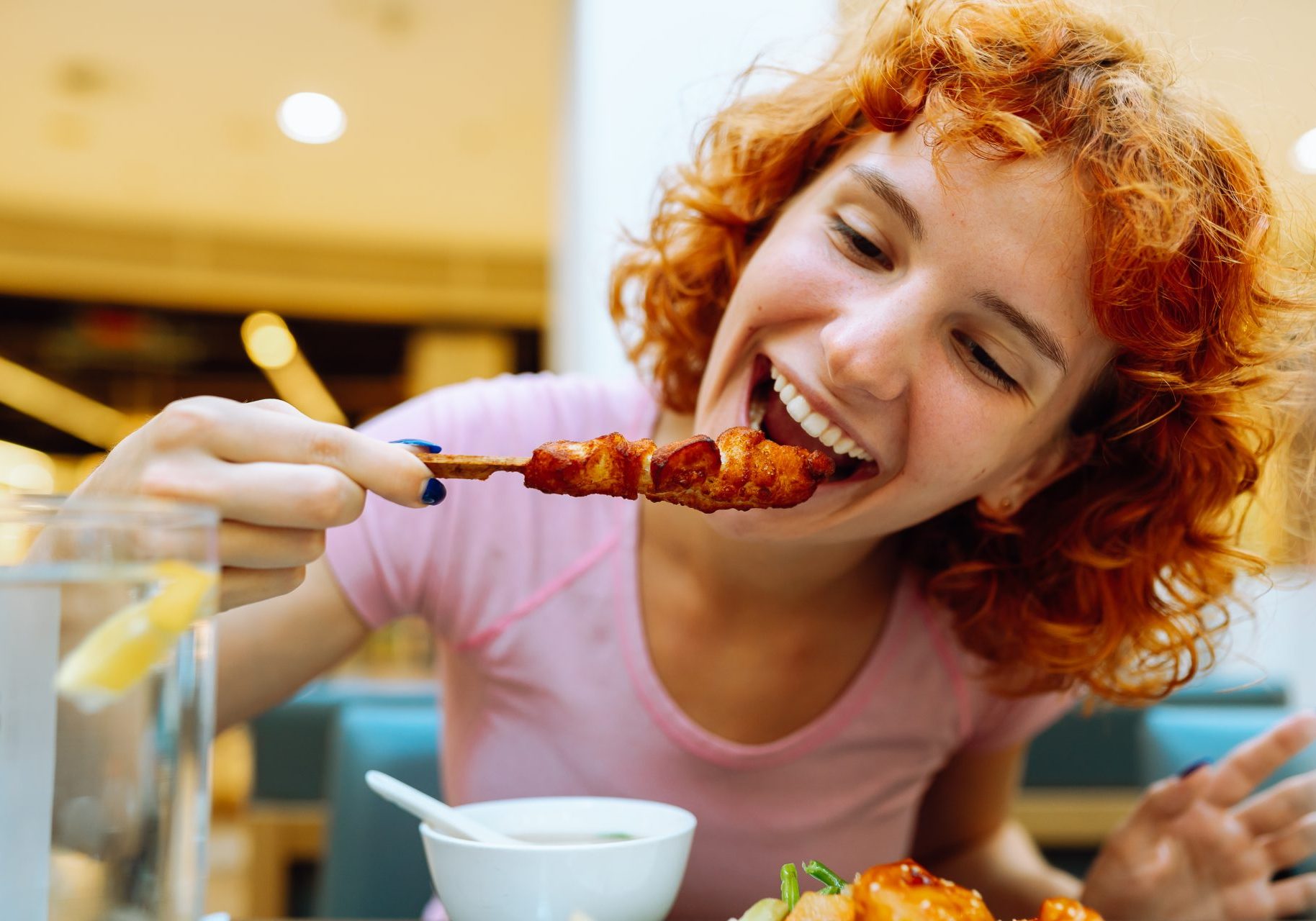 vitamina-b3_cover ragazza dai capelli rossi mangia spiedino di pollo