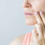donna indica neo vicino alla bocca