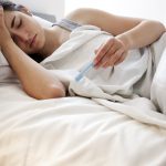 donna con febbre a letto misura temperatura