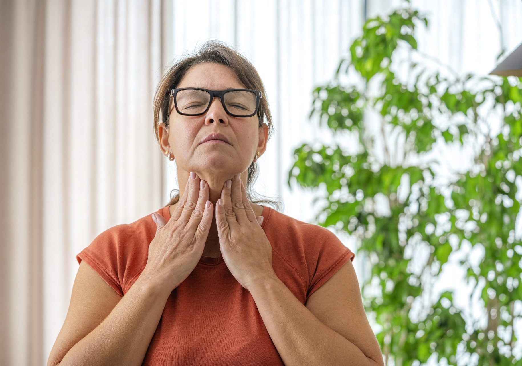 ipertiroidismo_cover donna matura tocca il collo dolorante con entrambe le mani