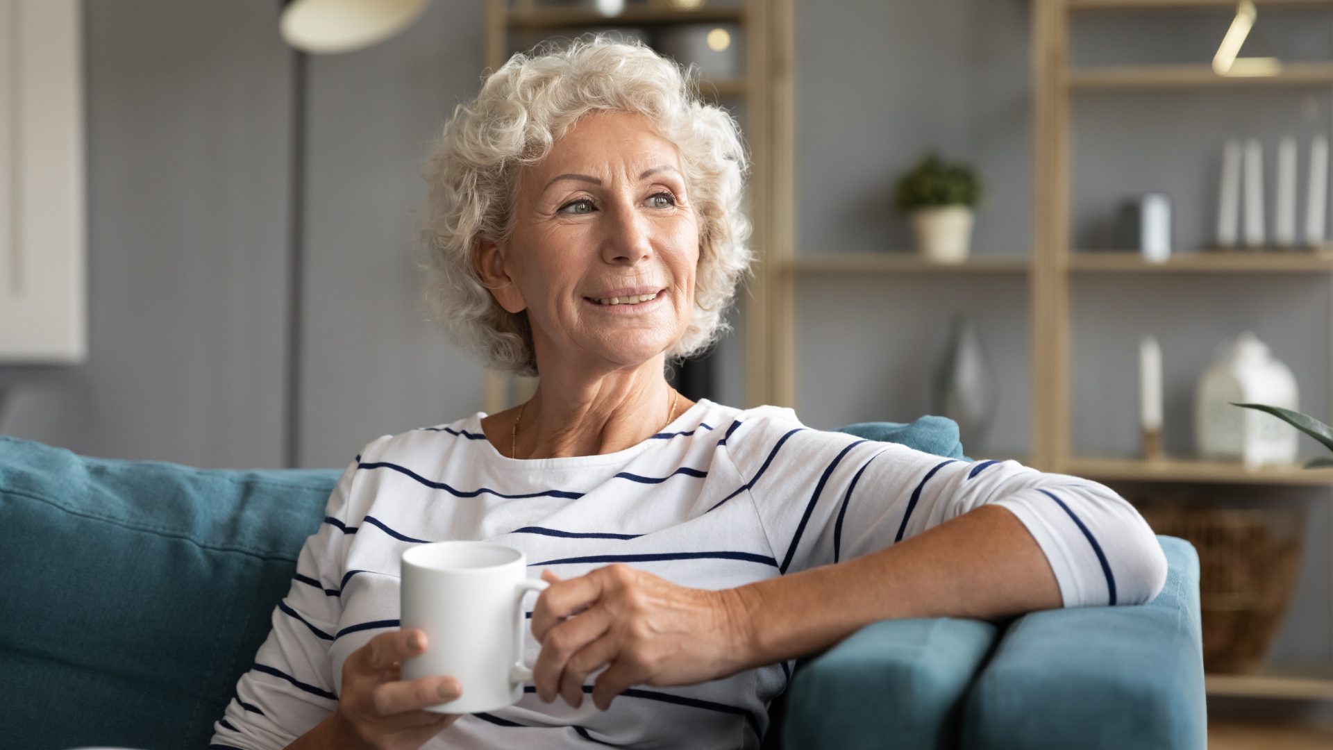 donna anziana con tazza di tè sul divano