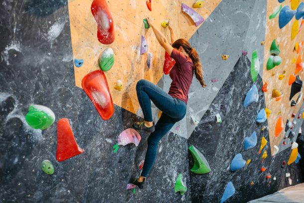 donna fa scalata sportiva indoor