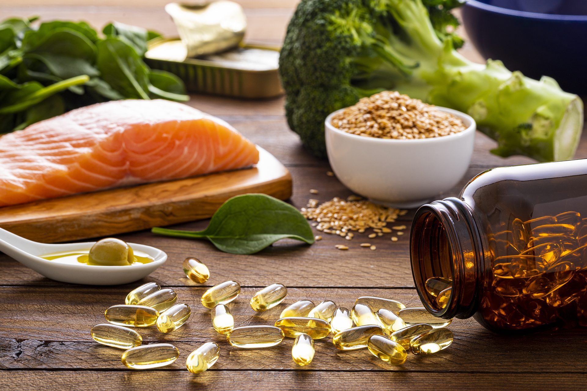 tavola con salmone, frutta secca, verdura e integratori di omega-3