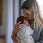madre affettuosa tiene in braccio neonato