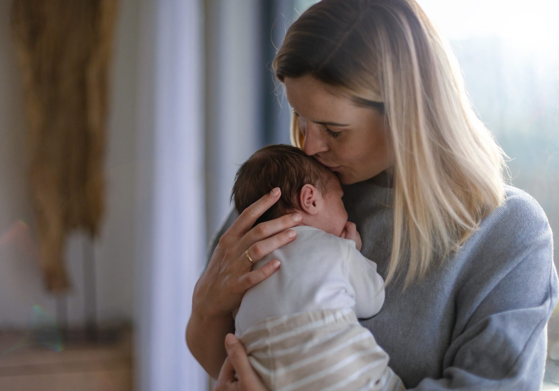 madre affettuosa tiene in braccio neonato