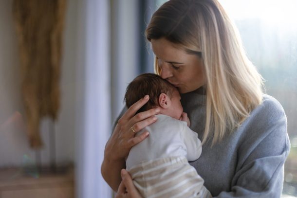 madre affettuosa tiene in braccio neonato