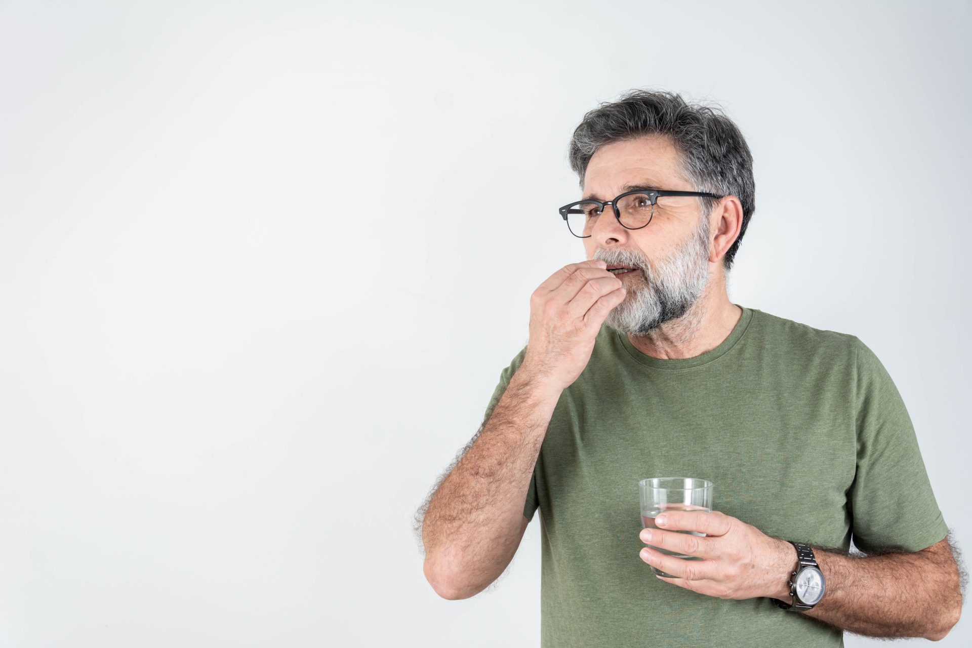 uomo prende pillola con bicchiere d'acqua