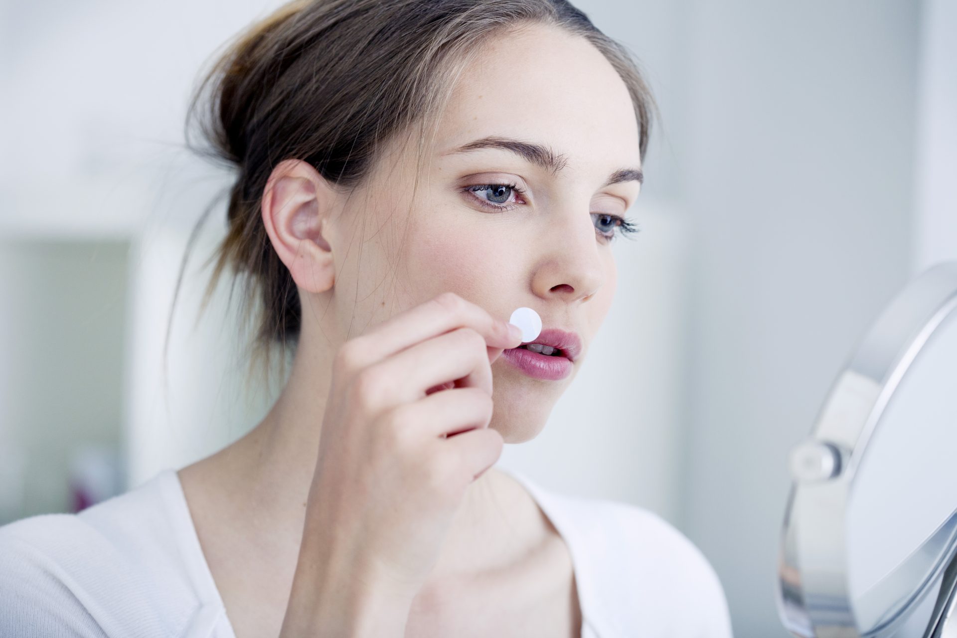 donna applica cerotto su herpes labiale