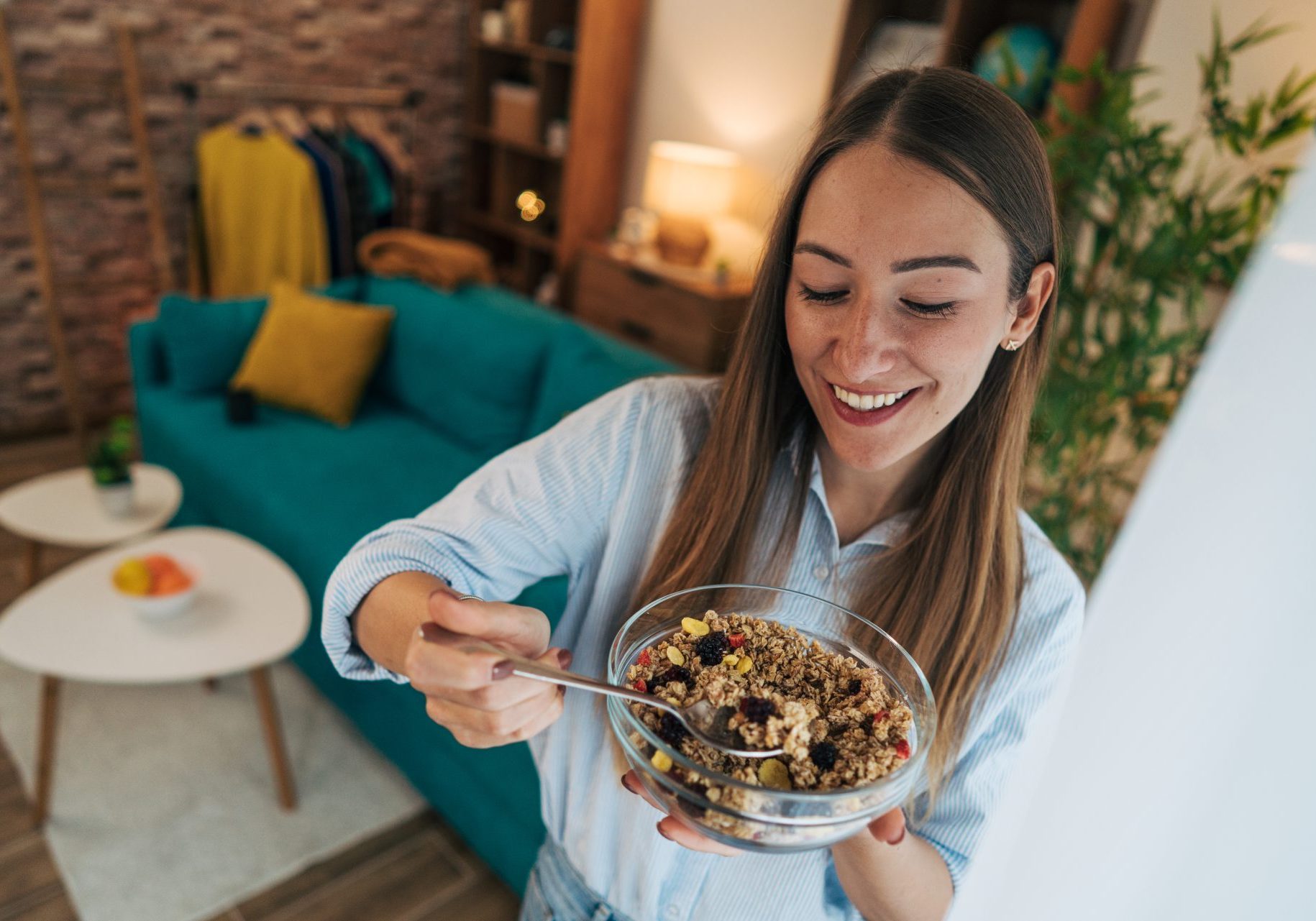 giovane donna mangia cereali da una ciotola