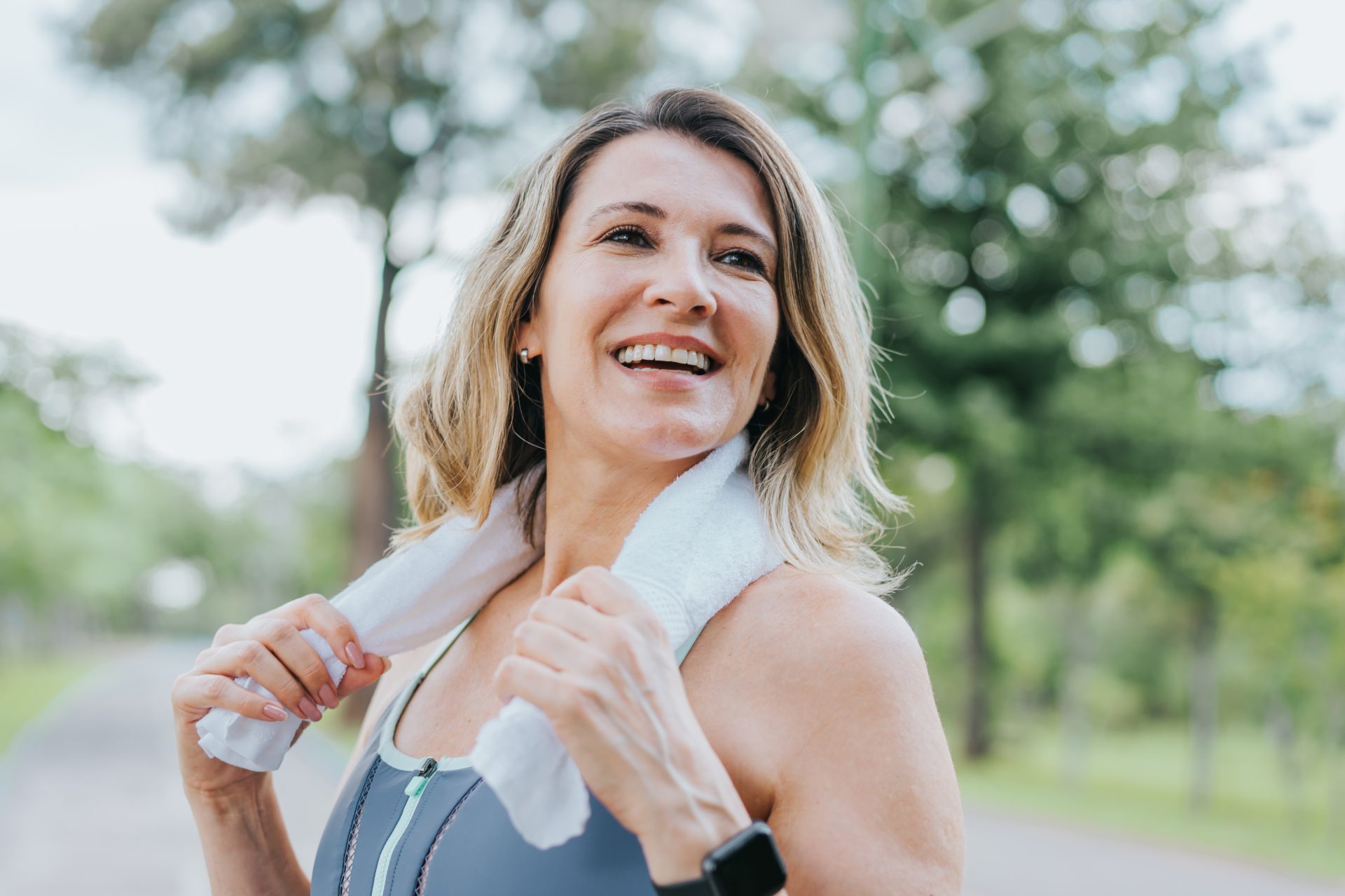 donna sorridente in tenuta sportiva all'esterno