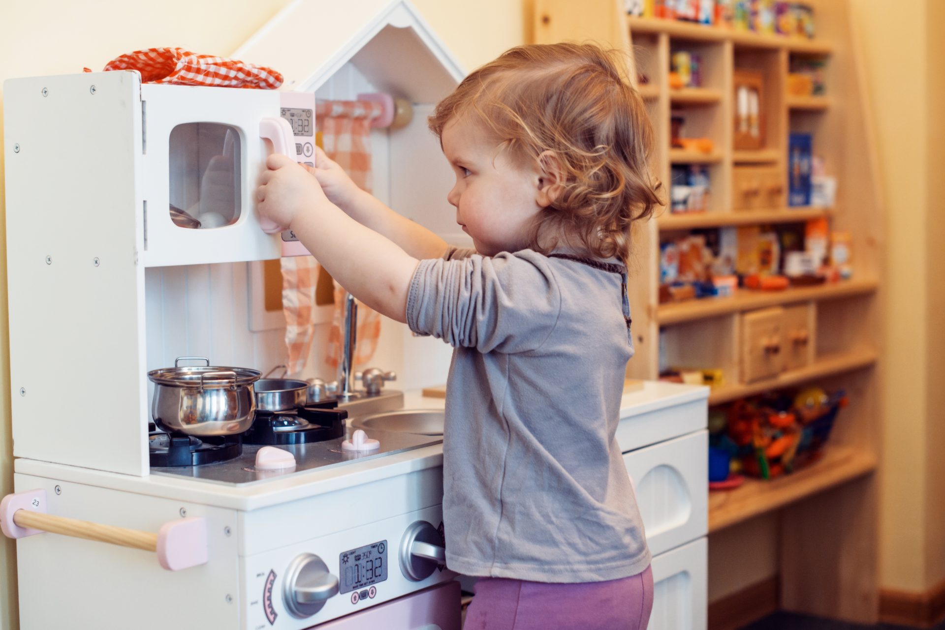 bambina gioca con una cucina giocattolo