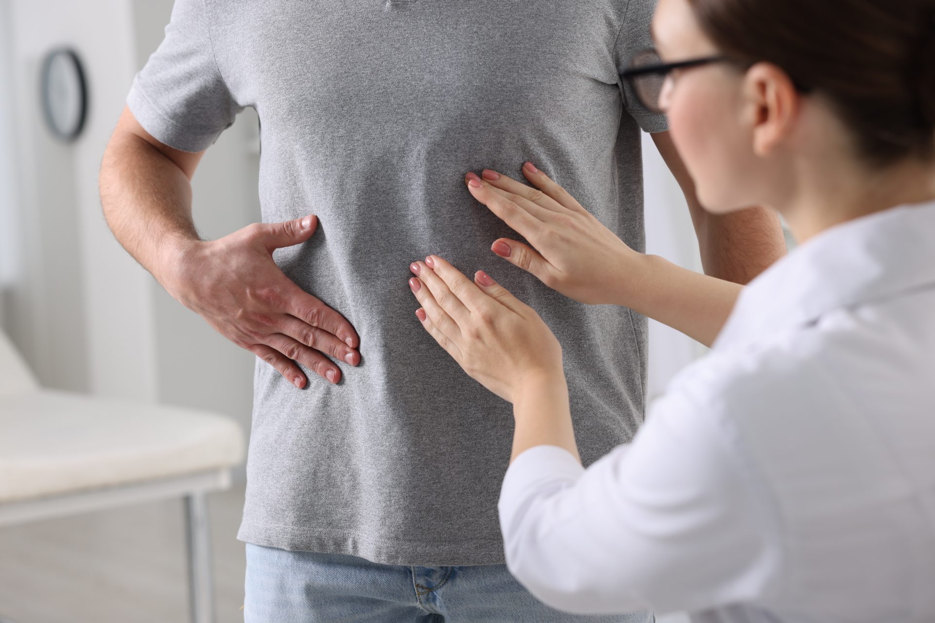 medico palpa l'addome del paziente