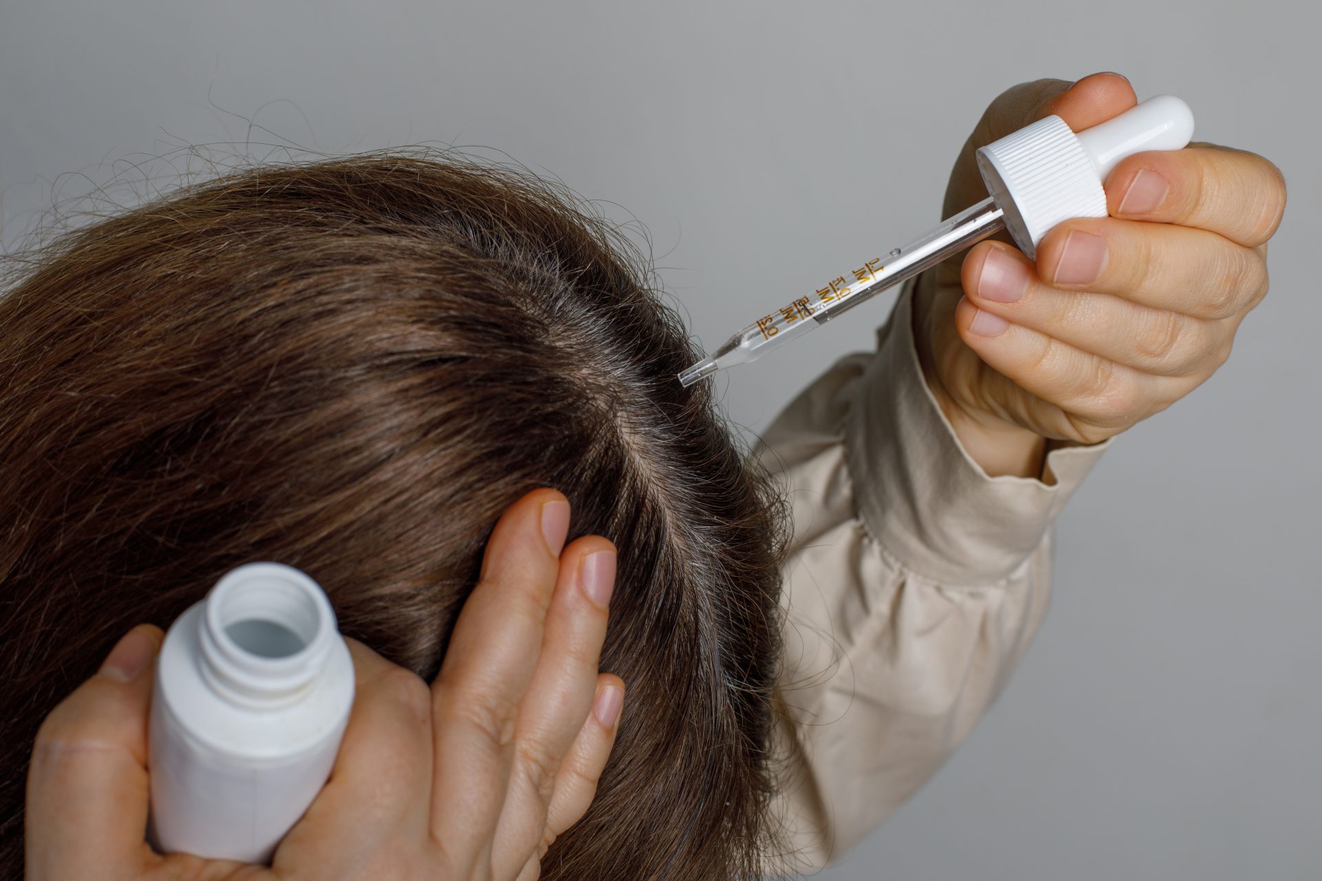 donna applica su capelli trattamento anticaduta