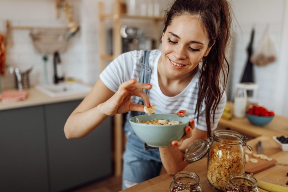 giovane donna prepara una ciotola per colazione
